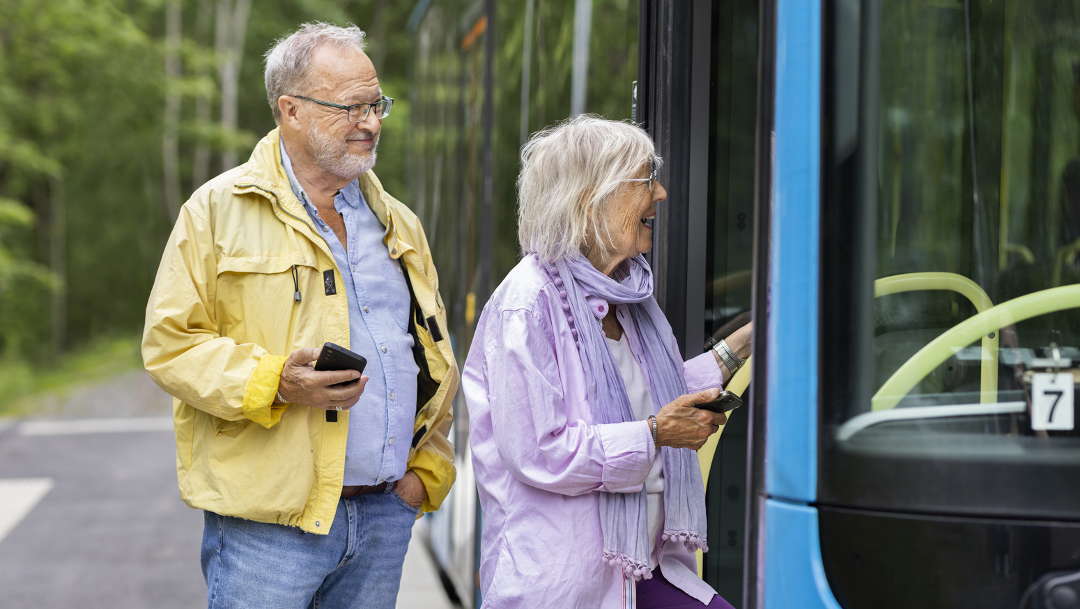 Två seniorer går ombord på en buss.